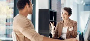 A woman and man speak in an office setting