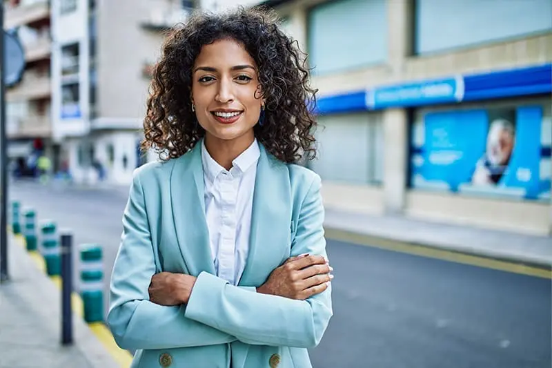 what-our-grads-earn Successful University of Denver graduate standing confidently in a professional city setting